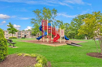 A playground with a red slide and a blue slide at Andrews Ridge Apartments, Suitland, MD